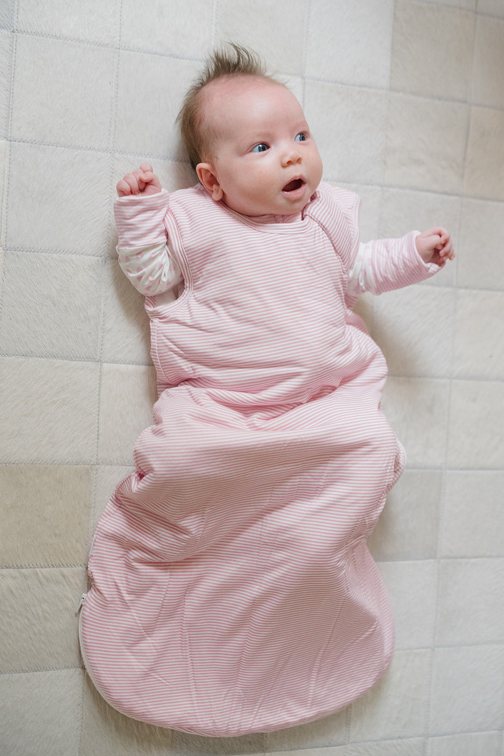 Pink striped baby sleeping bag on a white background