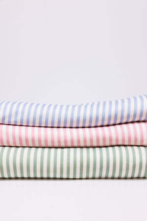 A stack of folded striped blankets in blue, pink, and green, arranged vertically with the striped patterns visible.