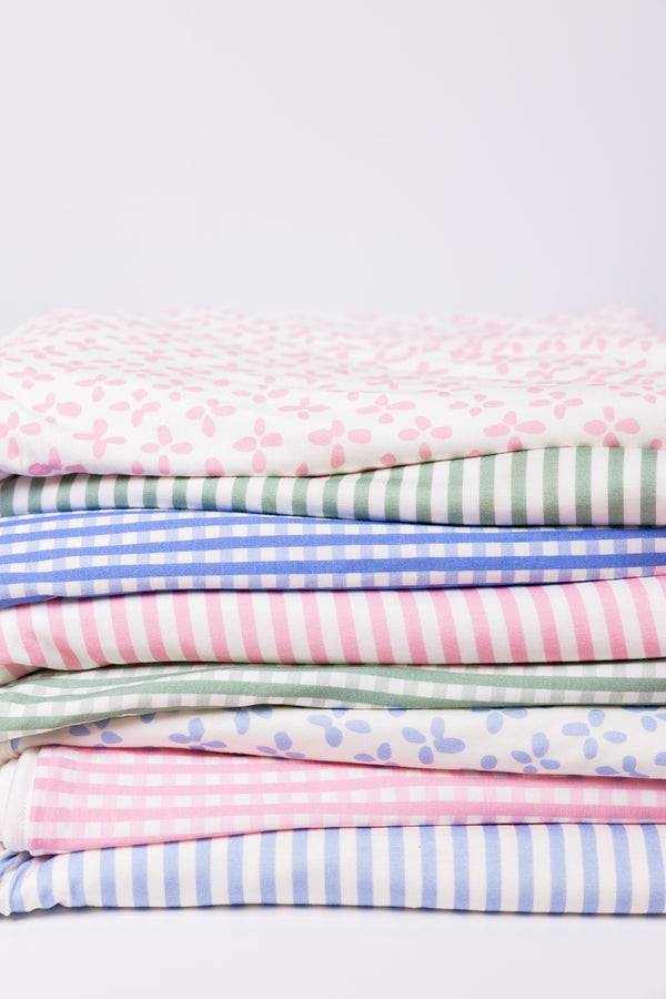 Folded assortment of blankets with white background. 