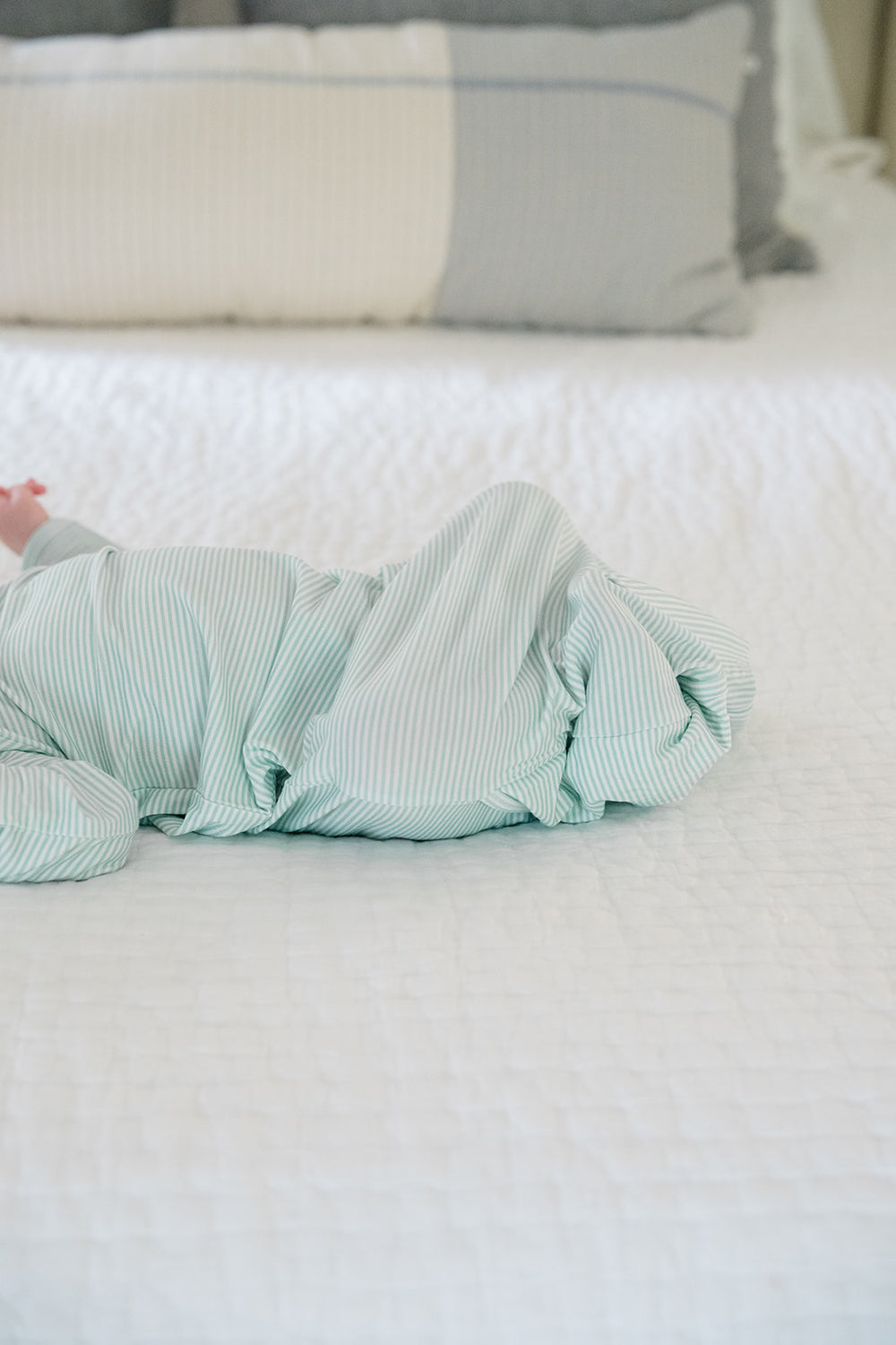 Green striped baby swaddle on a white background