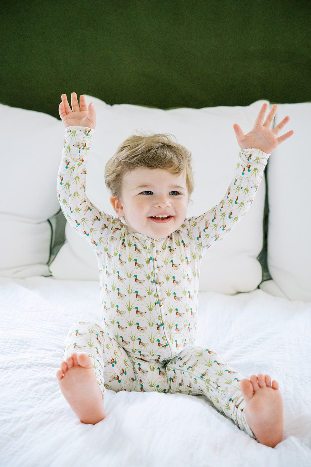 Baby onesie with duck and grass pattern on a white background