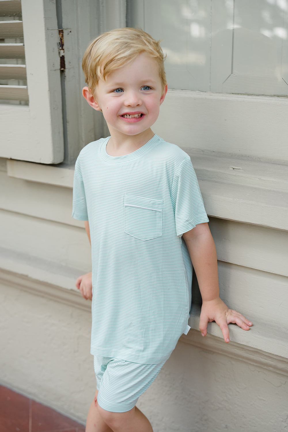 Children's green striped shirt and shorts set with a tag on a white background