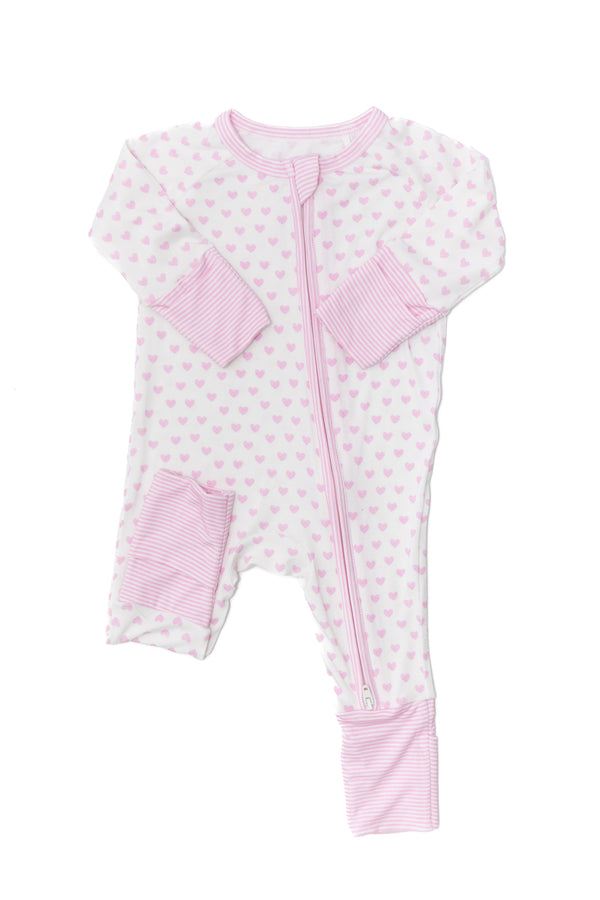 Pink baby onesie with white polka dots on a white background